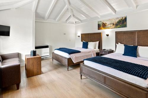 a hotel room with two beds and a couch at Carmel Resort Inn in Carmel