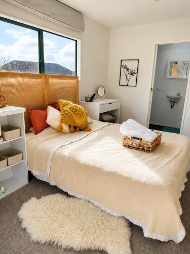 a bedroom with a large bed with a large window at Pine Grove Retreat in Auckland
