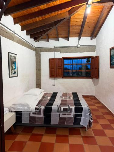 a bedroom with a large bed with a wooden ceiling at Villa Palosanto Campestre in Jericó