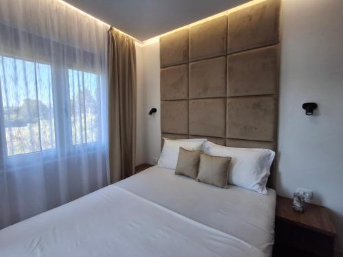 a bedroom with a large white bed and a window at Stars Five Stay in Ulcinj
