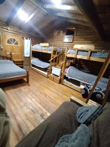 a room with several bunk beds in a cabin at Quincho Cabaña Las Marias in Ciudad Lujan de Cuyo