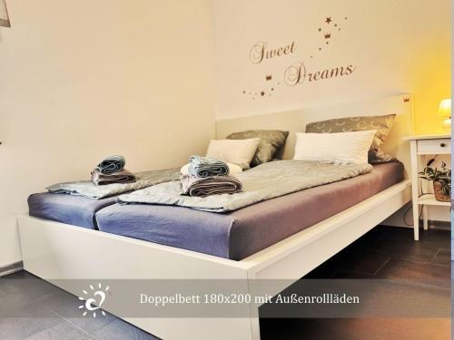 a bed in a small room with a sign that reads sweet dreams at Nordprinz mit Sauna und Whirlpool in Geestland