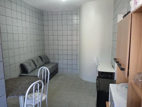 a small room with a couch and a table and chairs at Studio aconchegante perto dos eventos! in Garanhuns