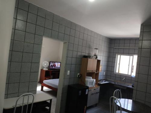 a small kitchen with a table and a room with a kitchen gmaxwell gmaxwell gmaxwell gmaxwell at Studio aconchegante perto dos eventos! in Garanhuns