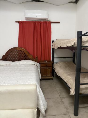a bedroom with two bunk beds and a red curtain at Los Romanos farm in Sauce Bajada