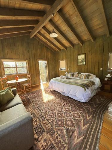 a bedroom with a large bed and a couch at Casona el Refugio Casablanca in Casablanca