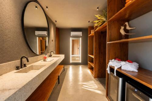 a bathroom with two sinks and a large mirror at Kamai Pousada Boutique in Pôrto de Pedras