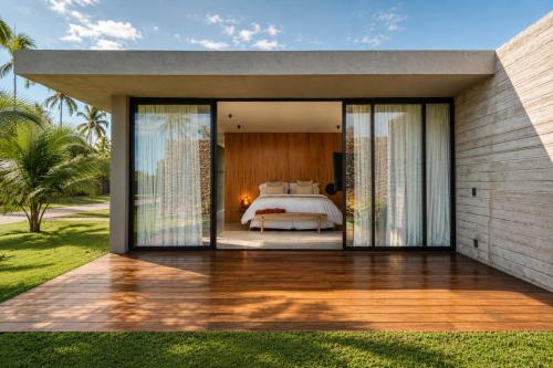 a bedroom with a bed and sliding glass doors at Kamai Pousada Boutique in Pôrto de Pedras