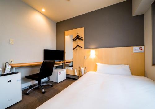 a bedroom with a bed and a desk with a computer at Super Hotel Nara Shin Omiya Ekimae in Nara