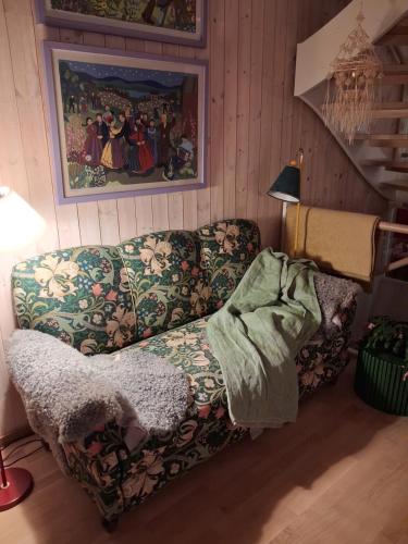 a living room with a couch and a painting at Sjöutsikt med bastu som tillval in Tällberg