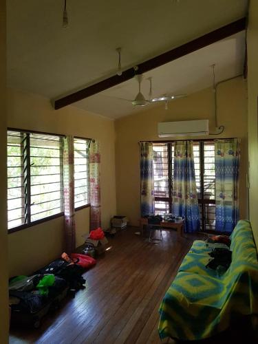 a living room with a bed and a wooden floor at Canopy cottage in Honiara