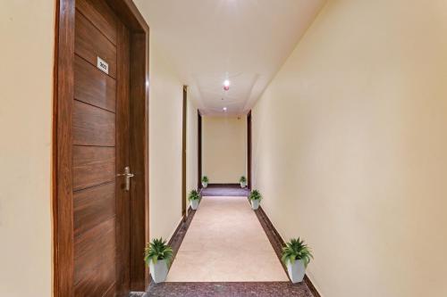 a hallway with a wooden door and two potted plants at Townhouse Hotel Spotlight in Nawābganj