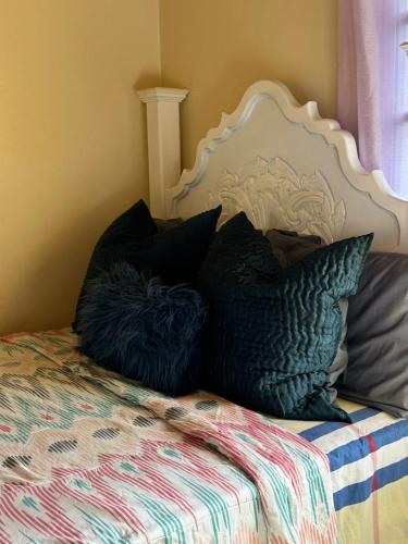 a bed with black pillows on top of it at Keisha's luxury stays in Santa Cruz