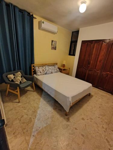 a bedroom with a bed and a chair at Double room with private bathroom in Santo Domingo