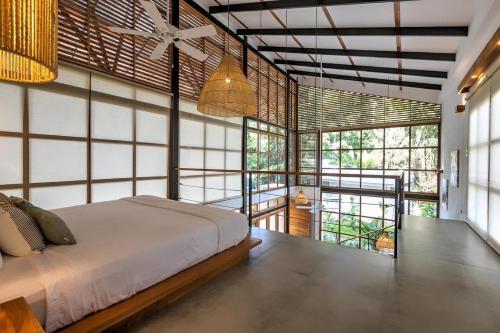 a bedroom with a bed in a room with windows at Porto Alegre Villas in Punta Uva