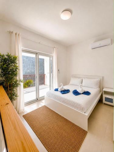 a bedroom with a white bed with a large window at Paraiso Destiny Duplex in Bayahibe