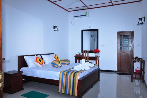 una camera da letto con un letto e uno specchio di Winmi Resort a Habarana