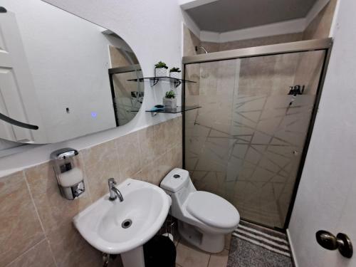 a bathroom with a sink and a toilet and a mirror at The terrazzo house in Santa Ana