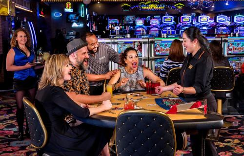a group of people sitting around a table in a casino at Four Queens Hotel and Casino in Las Vegas