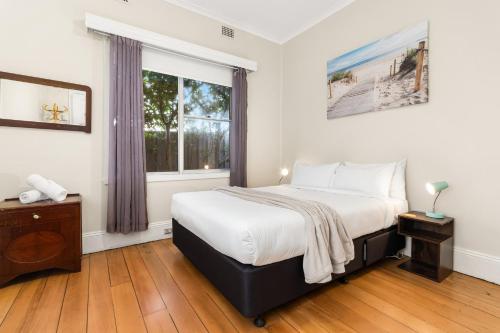 a bedroom with a large bed and a window at Stockton Coastal Escape in Stockton