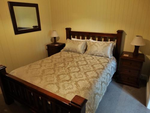 una camera da letto con un grande letto con due comodini di Loughmore House a Eukey