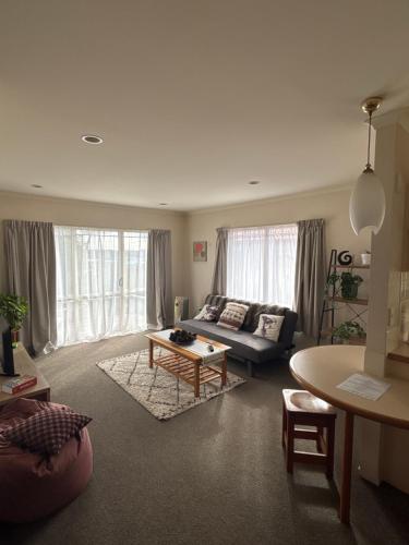a living room with a couch and a table at Sunsets over Unsworth in Auckland