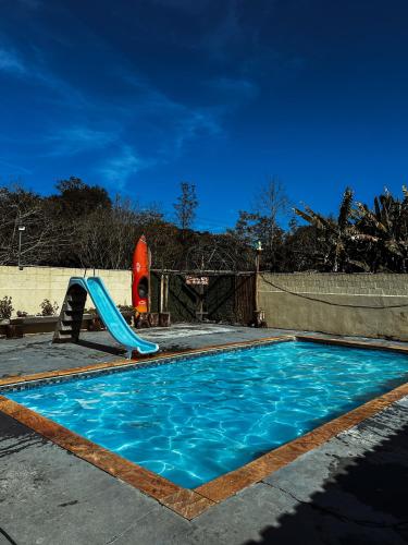 a swimming pool with a slide and a playground at Kombi do Scooby-Doo in Mairiporã