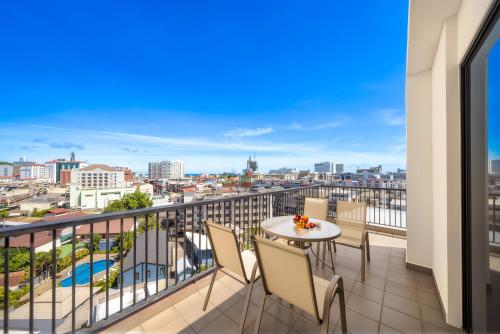 a balcony with a table and chairs and a view of the city at Tycoon Holiday Hotel in Pattaya