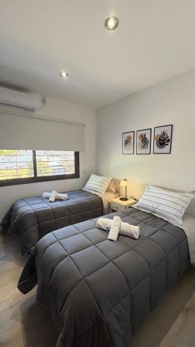 a bedroom with two beds with towels on them at Base de los Andes 4 in Maipú
