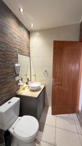 a bathroom with a white toilet and a sink at Base de los Andes 4 in Maipú