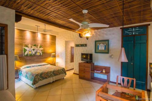 a bedroom with a bed and a wooden ceiling at Pousada Luz Do Sol in Porto Seguro