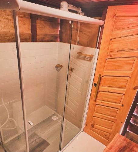 a shower with a glass door in a room at Pousada Luz Do Sol in Porto Seguro