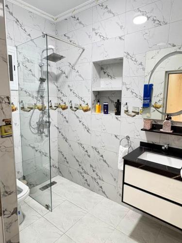 a white bathroom with a shower and a sink at Dar marhaba in Tangier