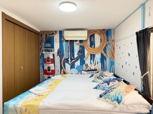 ein Schlafzimmer mit einem großen Bett und blauen Wänden in der Unterkunft Yui HOSTEL in Tokio