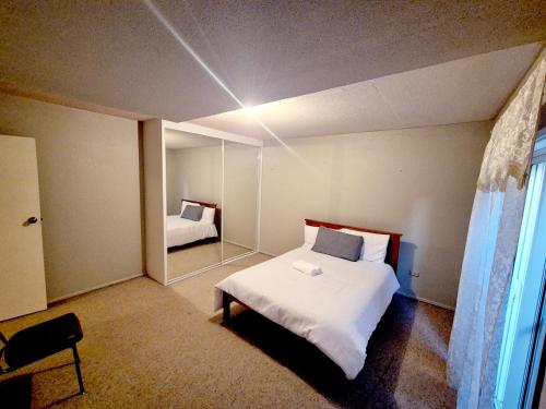 a bedroom with a white bed and a mirror at Kaban Power 11 in Marayong