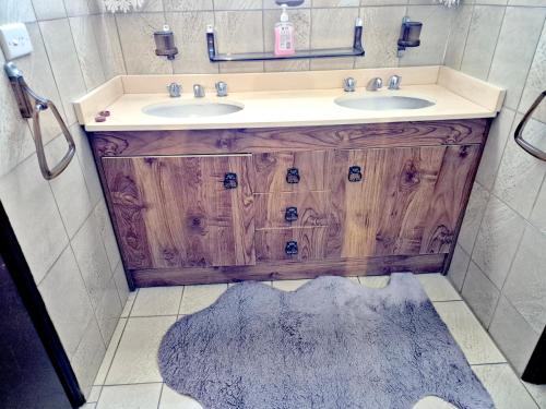 a bathroom with a wooden vanity with two sinks at Kaban Power 11 in Marayong