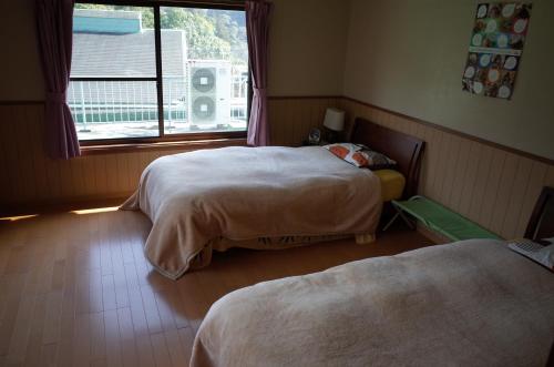 高千穂町にある貸別荘 高千穂峡のベッドルーム1室(ベッド2台、窓付)