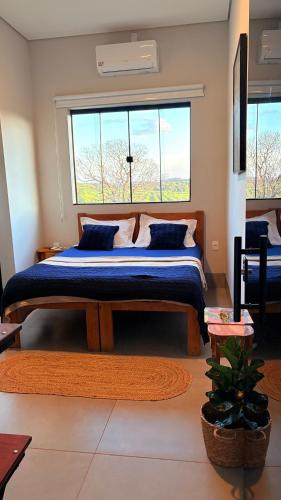 a bedroom with a large bed with a large window at Pousada Veredas da Canastra in Delfinópolis