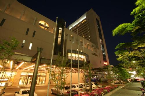 un edificio con coches estacionados en un estacionamiento por la noche en Kobe Seishin Oriental Hotel, en Kobe