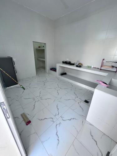 a room with a white tiled floor with a counter at كوس الاشخرة in Al Sharqiyah