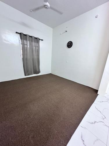 an empty room with white walls and a window at كوس الاشخرة in Al Sharqiyah