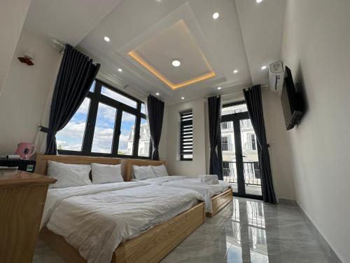 a bedroom with a large bed in a room with windows at House 1994 in Xuan An