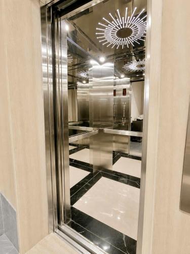 a glass hallway with a shiny floor and a chandelier at Urban Nest - Cầu Giấy in Hanoi