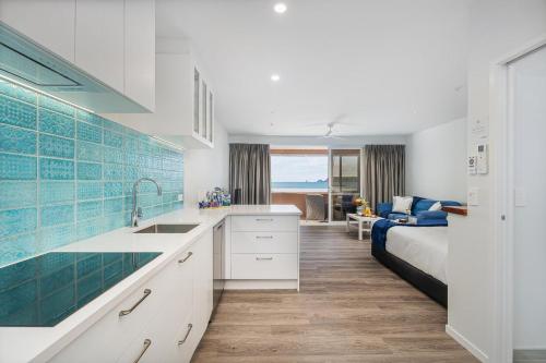 a kitchen with a sink and a bed in a room at Seaview Studio Apartment - Beachfront with Heated Pool in Whitianga