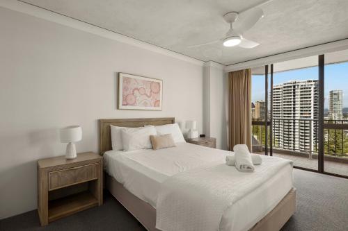 a bedroom with a bed and a large window at Breakers North Absolute Beachfront Apartments - Official in Gold Coast