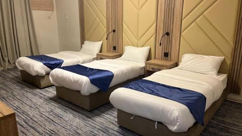 a room with three beds in a room at انهار للشقق المخدومة in Taif