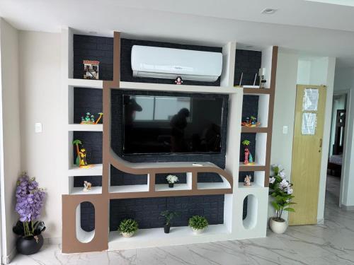 a living room with a tv on a wall at Departamento moderno con jacuzzi privado - Porto Vitoria in Tonsupa
