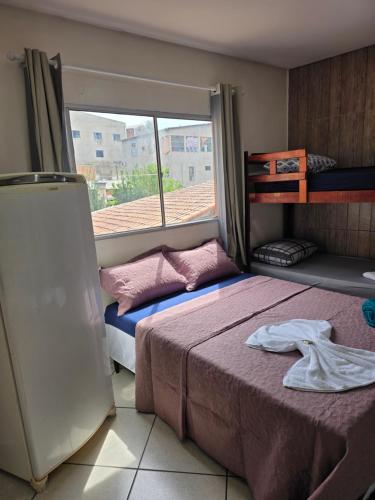 a bedroom with two beds and a window at Pousada Dubai in Cuiabá