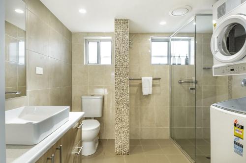 a bathroom with a toilet and a sink and a shower at Apartment 4B in Lennox Head
