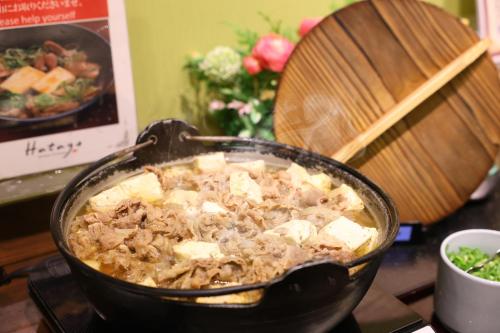a pot of food on top of a stove at Dormy Inn Premium Osaka Kitahama in Osaka